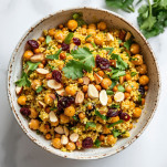 Moroccan-inspired chickpea quinoa salad with turmeric, almonds, and fresh cilantro in a ceramic bowl