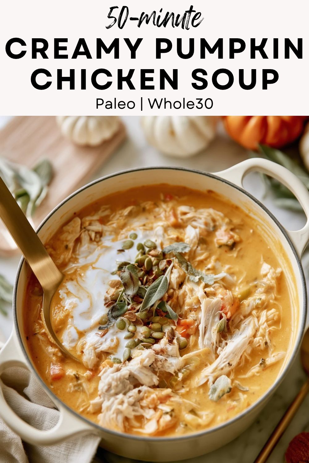 pinterest-ready image of creamy pumpkin chicken soup with shredded chicken and pepitas in a cream Dutch oven on white marble